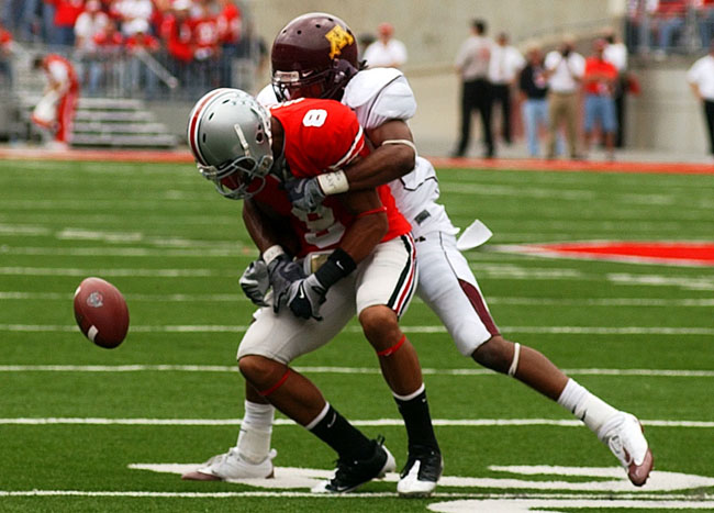 Ohio State safety Aaron Grant loses control of a pass while Minnesota cornerback Traye Simmons tackles him, producing an incomplete pass.