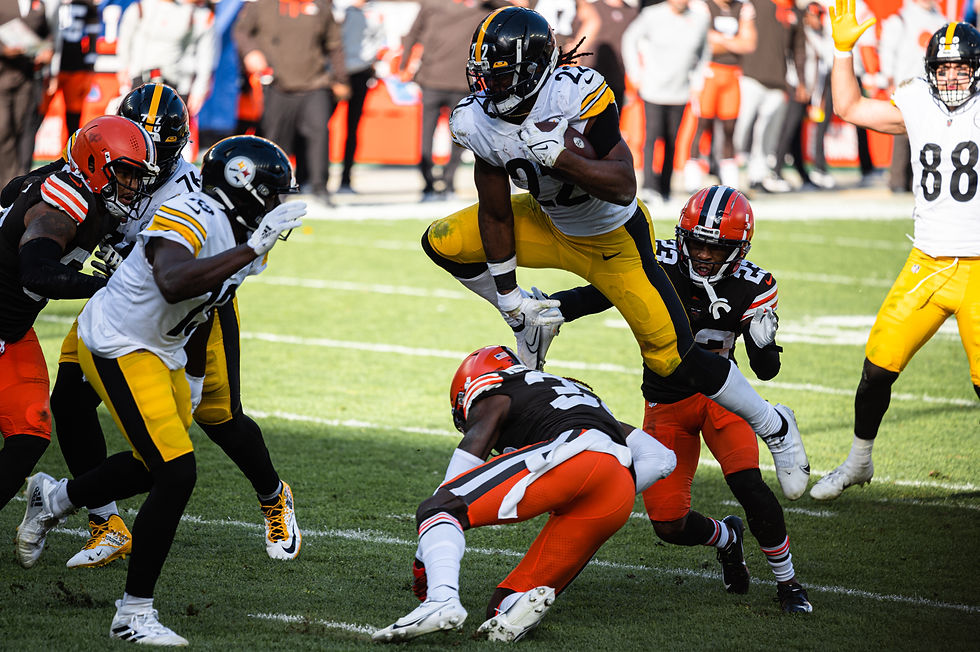 Pittsburgh Steelers running back carrying the ball against Cleveland Browns defenders at Huntington Bank Field in a 2021 game