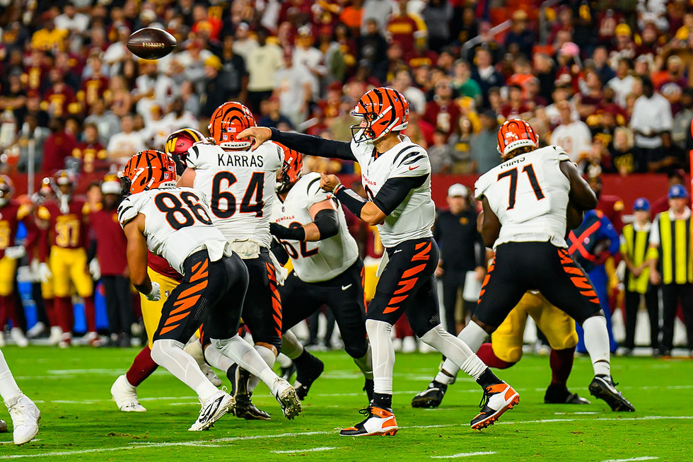 Joe Burrow in a white Cincinnati Bengals No. 9 uniform passes from the pocket against Washington during an August 18, 2025 preseason game.