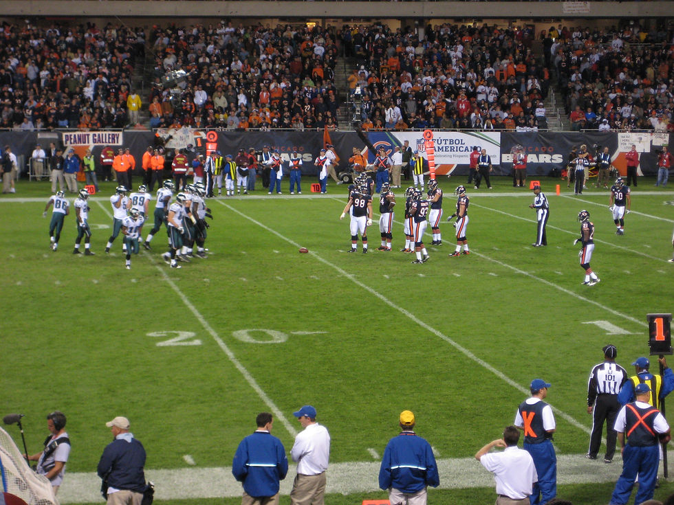 Philadelphia Eagles and Chicago Bears players line up at Soldier Field during a night game