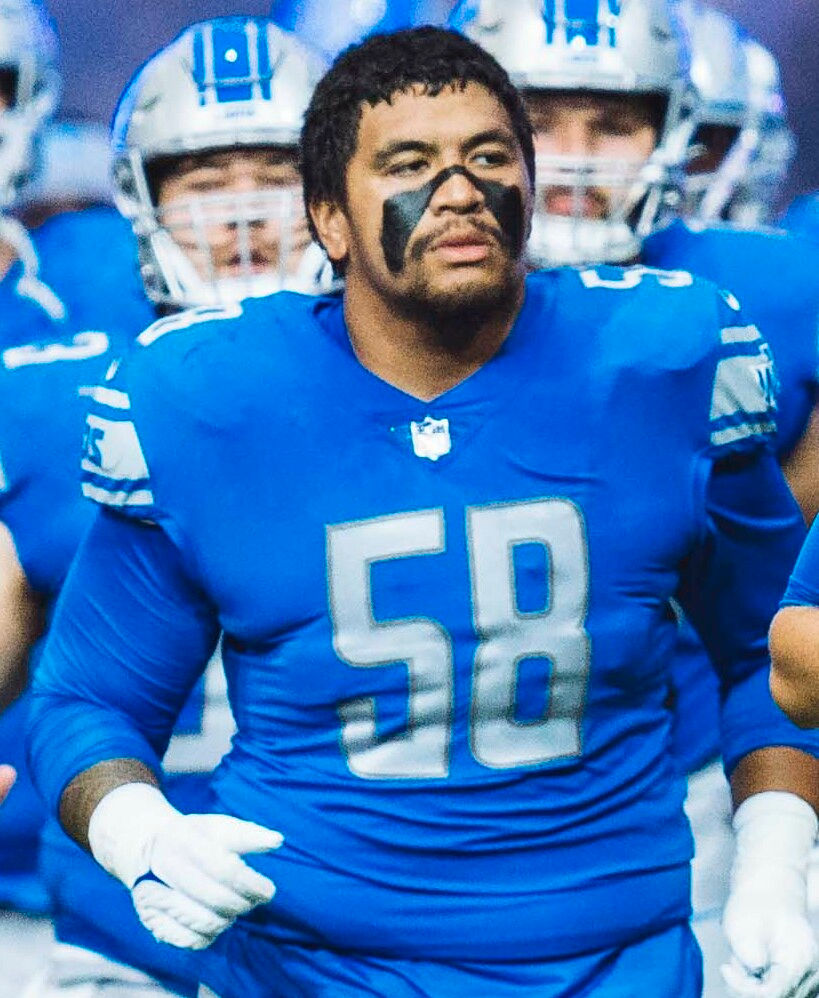 Penei Sewell leads the Detroit Lions onto the field at Ford Field before a 2022 game.