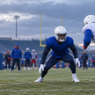 Two anonymous football defenders practice in blue, navy and red uniforms before a Week 8 matchup