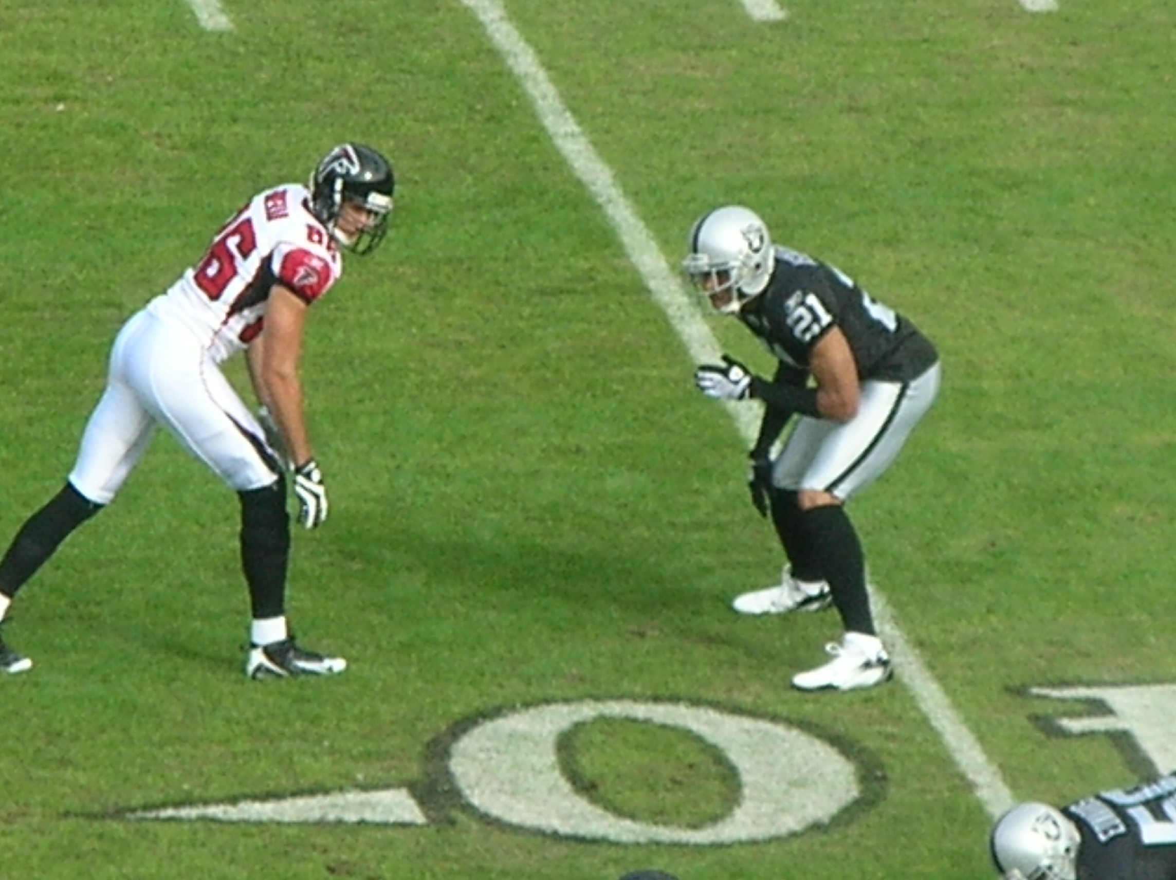 Cornerback Nnamdi Asomugha covers receiver Brian Finneran during an NFL game, illustrating close downfield coverage.