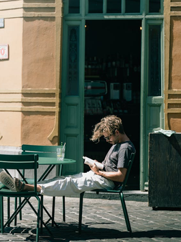 Man Sitting on Chairs and Reading