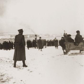 A Serbian policeman guards a group of Jewish refugees from the Kladovo transport walking around the banks of the Danube.jpeg