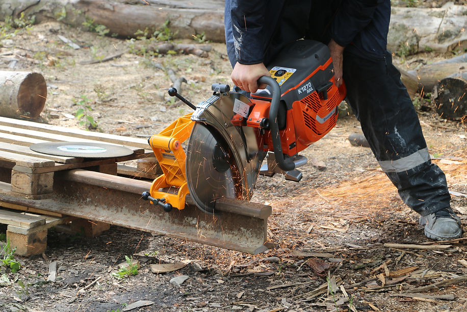 a man cutting a rail steel with diamond blade using a handheld petrol saw