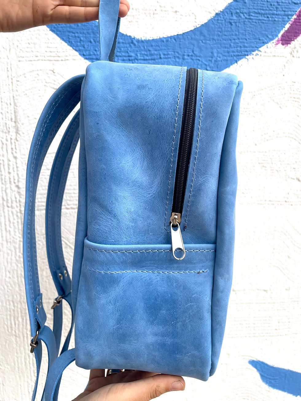 Μικρογραφία: side view of blue leather backpack with adjustable leather strap and zipper detail