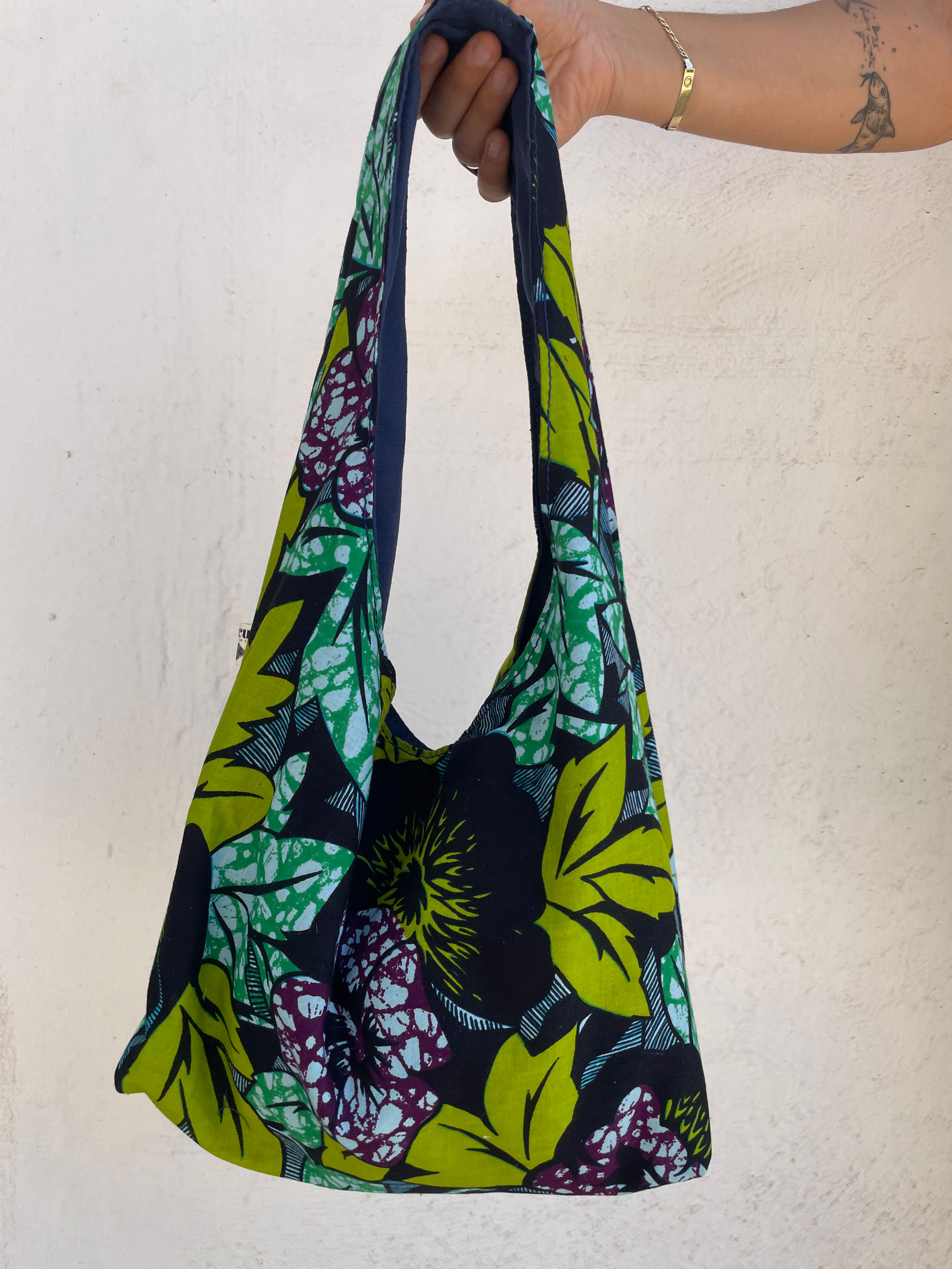 Front view of handmade green and purple floral fabric hobo bag, made in Crete.