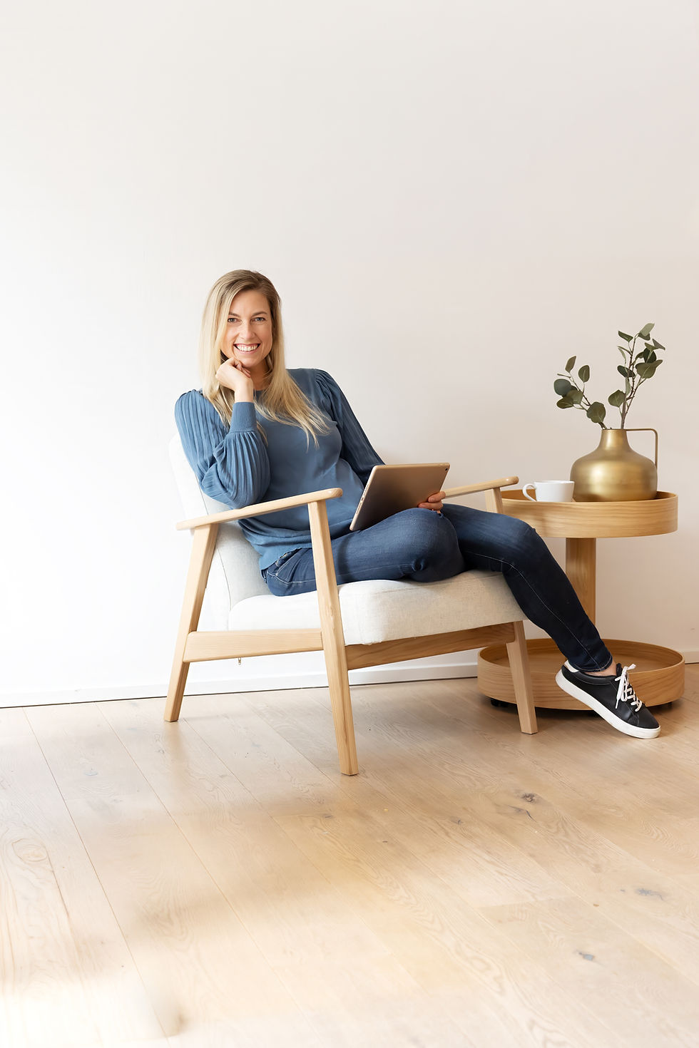 Coach Jennifer Kerbusk, sitzt auf Sessel mit Tablet in der Hand