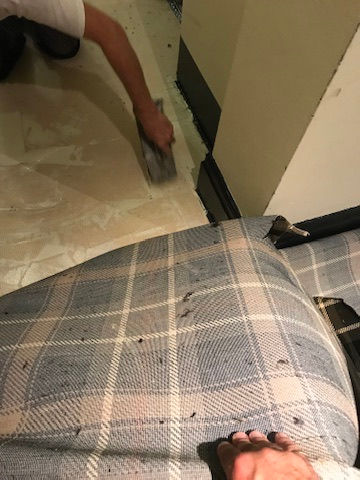 Soho Maintenance Ltd cleaning floor next to a sofa.