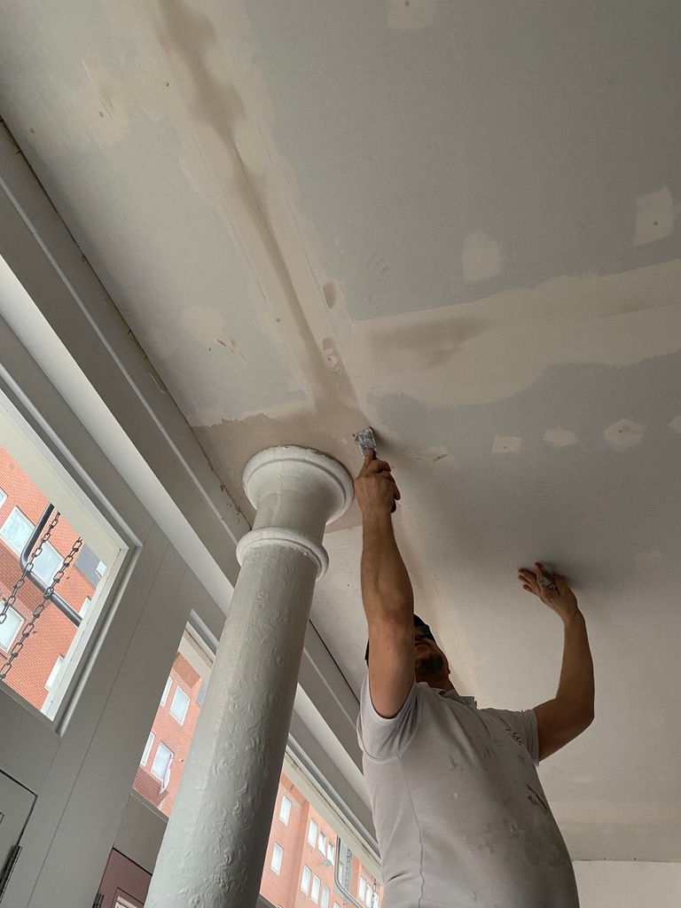 Worker plastering ceiling