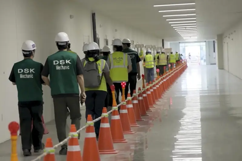 從ICE截錄的影像顯示,戴著安全盔的喬治亞州埃拉貝爾市電池工廠移民工人排隊等候檢查身分。(美聯社)