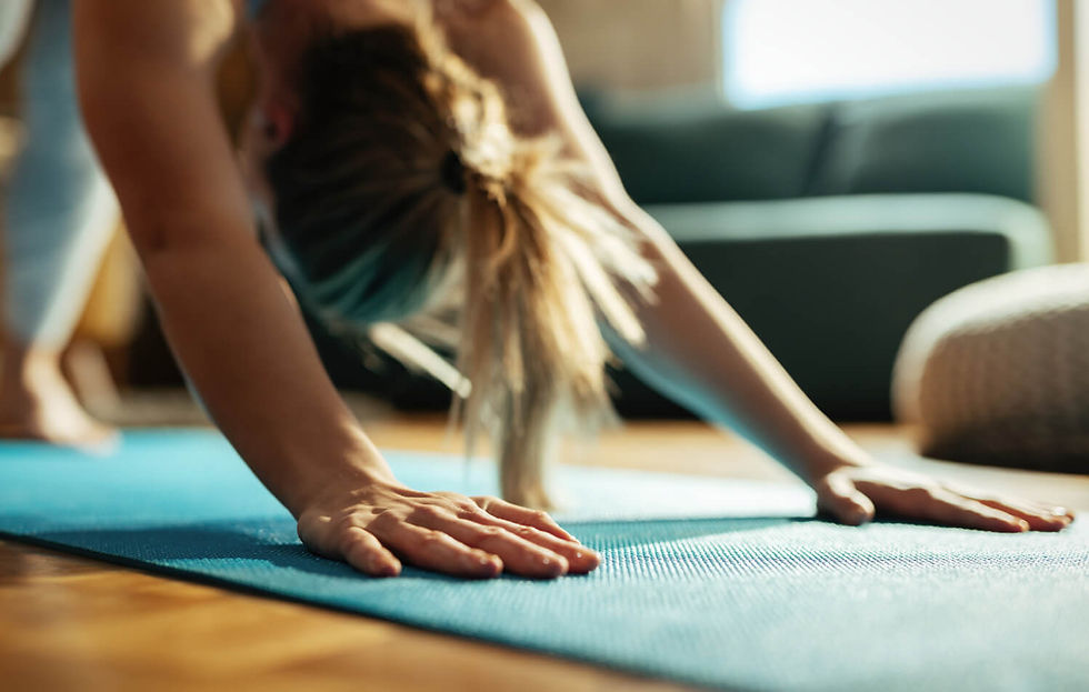 622500f5d91be13e90e1fee8_Woman in downward dog on a yoga mat in her living room.jpg