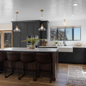 a modern kitchen with black cabinets and stone counter tops