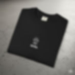 A black t-shirt featuring a small white line drawing of a grill with smoke above it and the word Grilla printed underneath