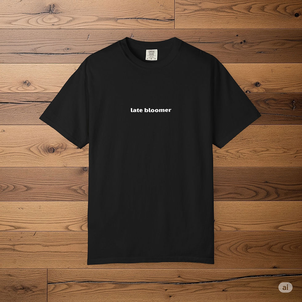 A black t-shirt with the words late bloomer printed in white lowercase letters on the chest