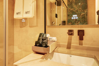 Modern hotel bathroom at April Hotel Aqaba with a glass walk-in shower, stone vanity, and an illuminated smart mirror.