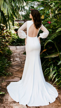 This beautiful soft crepe V-neckline dress is shaped so it hugs your curves and the gorgeous tulle balloon sleeves are appliquéd with lace leaves and sequins, leading down into a satin cuff with pearl buttons.