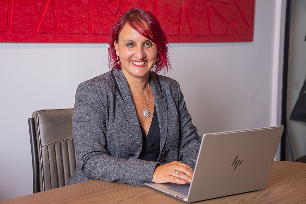 Woman with red hair smiling at a laptop, professional headshot photography