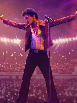 Bruno Mars performing live on stage under bright lights with cheering crowd at Wembley Stadium.