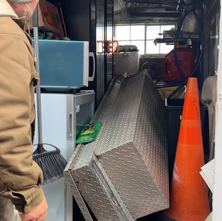 A man looking into a cluttered food trailer