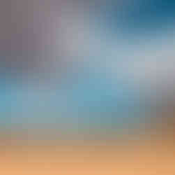 A cloudy sky over a vast golden field with barns in the background
