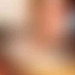 A hand flattens out cookie dough on a wooden table lined with flour. Rolling pins and cookie cutters are in the foreground.