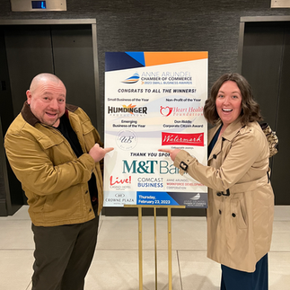 A man and a woman excitedly point to a sign 