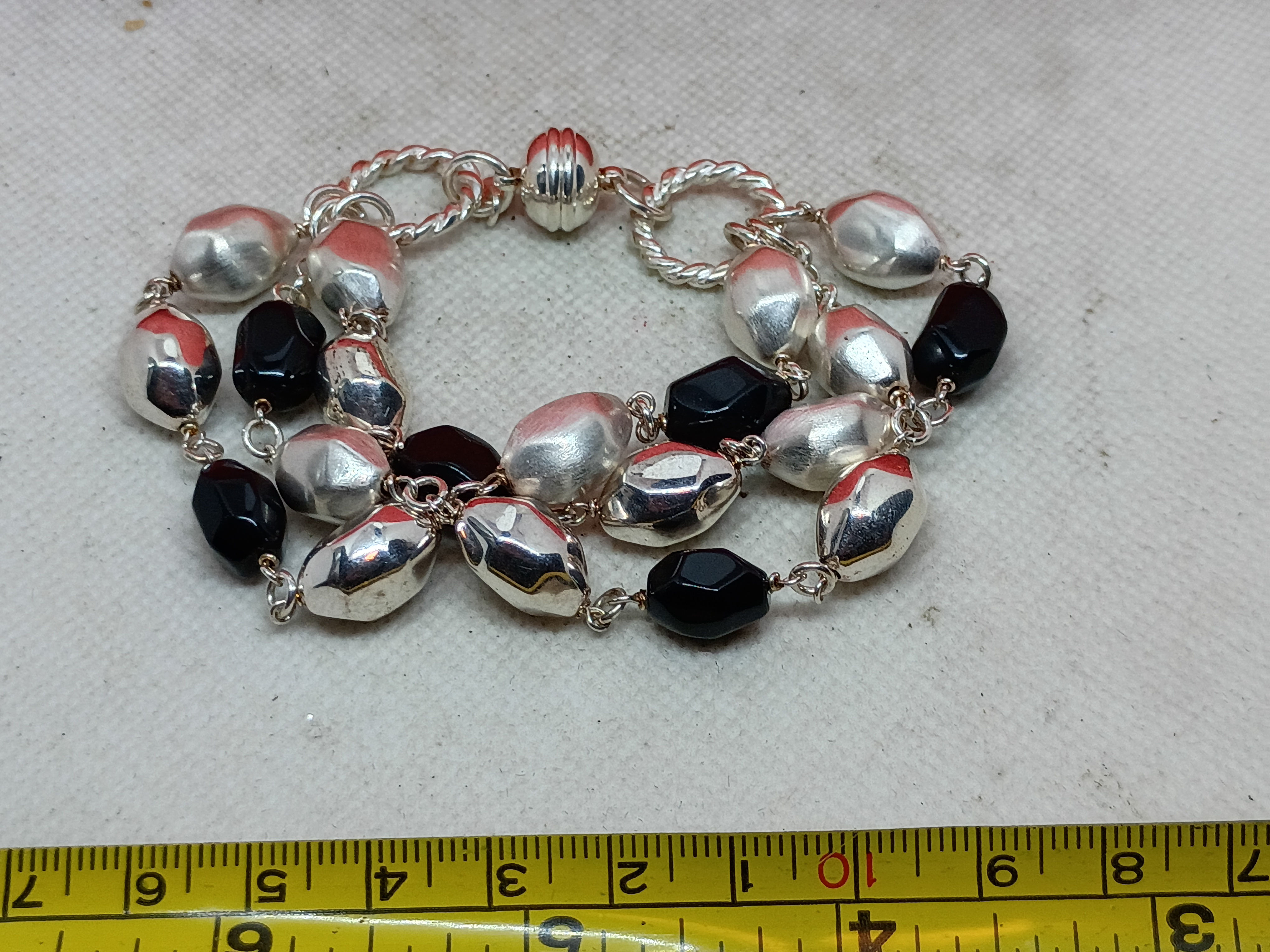 Multi-strand bracelet- irregular hammered silver beads and faceted black stones