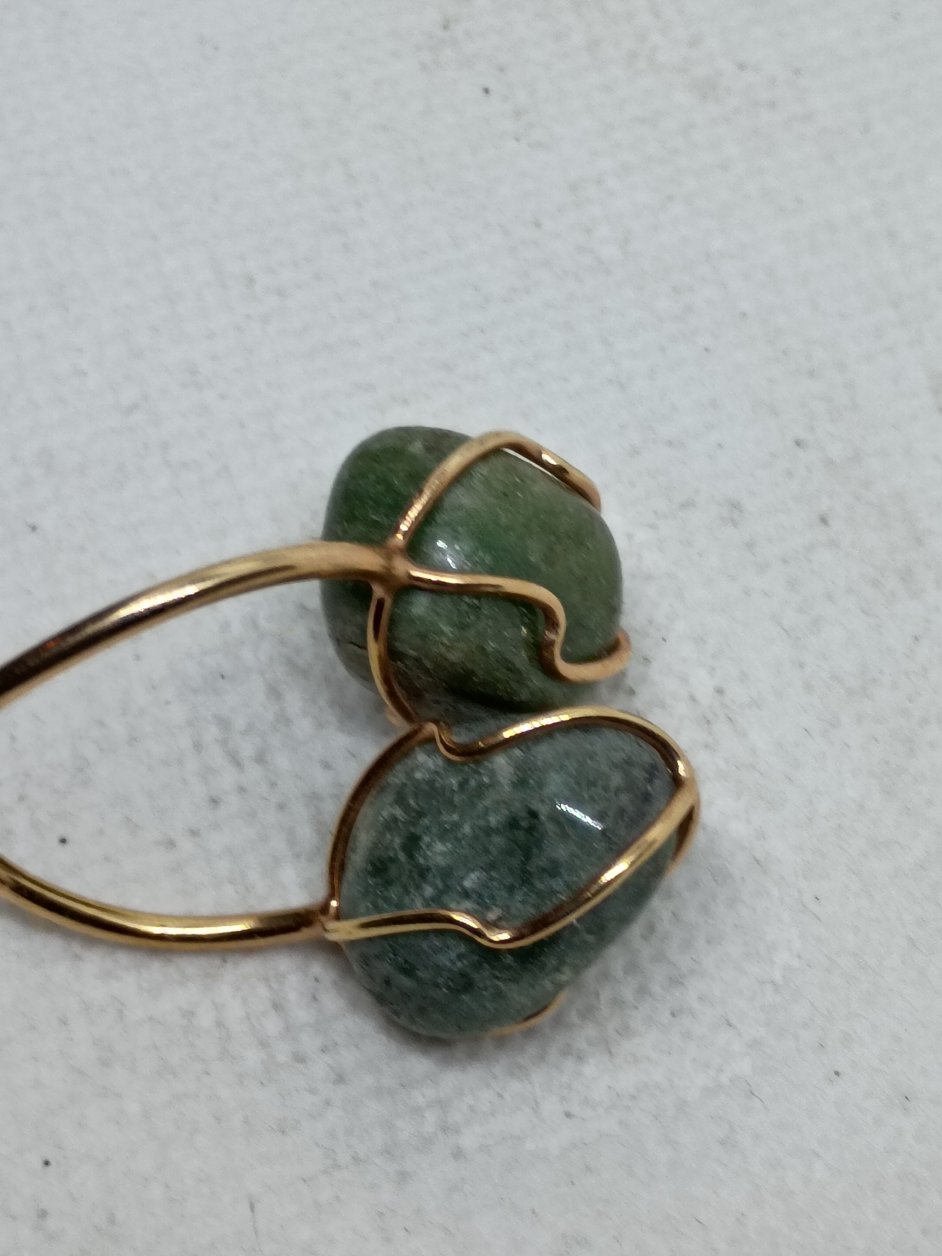 Artisan ring features two wire-wrapped green gemstone cabochons
