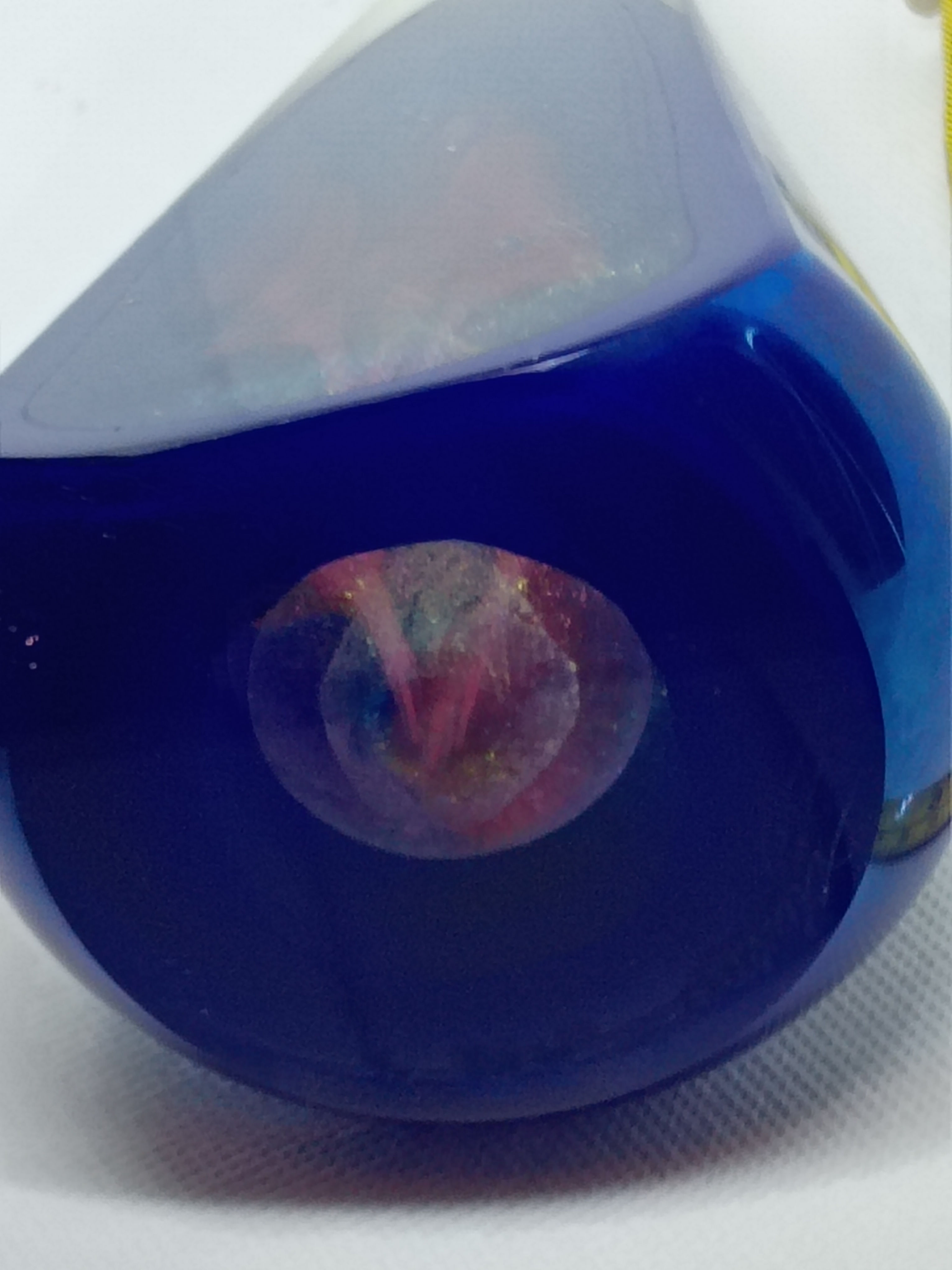 8" tall round clear and dark blue glass paperweight-red flowers inside