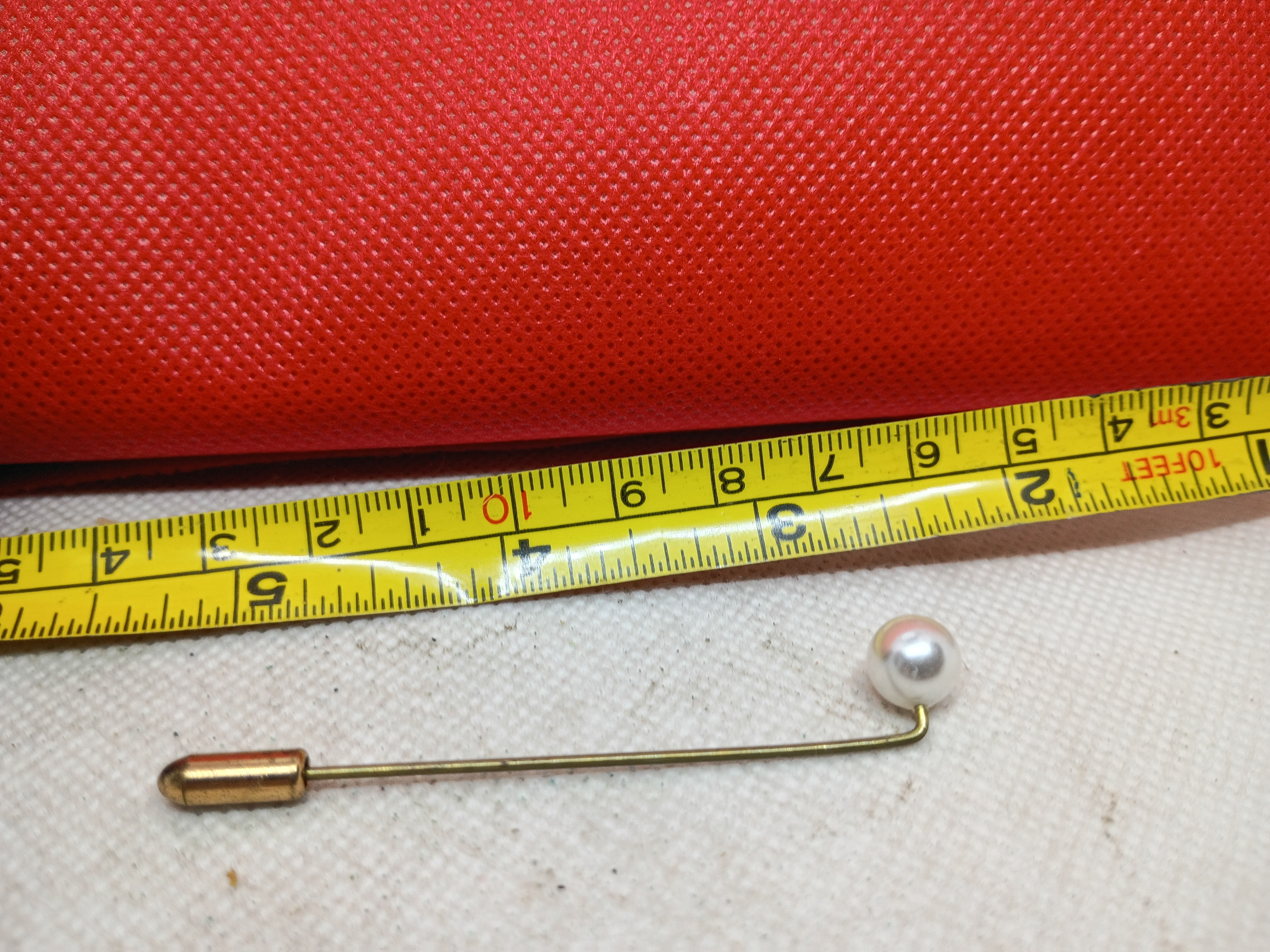 2.75" a vintage gold-tone stick pin featuring a single iridescent pearl and cap