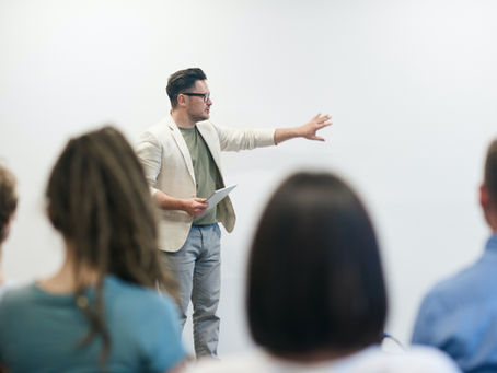 A male presenting to a group of business professionals.
