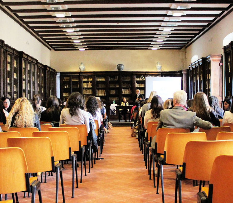 Rear view of community meeting looking down center aisle of orange chairs