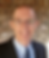 Bio photo of Daniel Baxter wearing dark sport coat, light blue shirt and patterned navy blue tie.