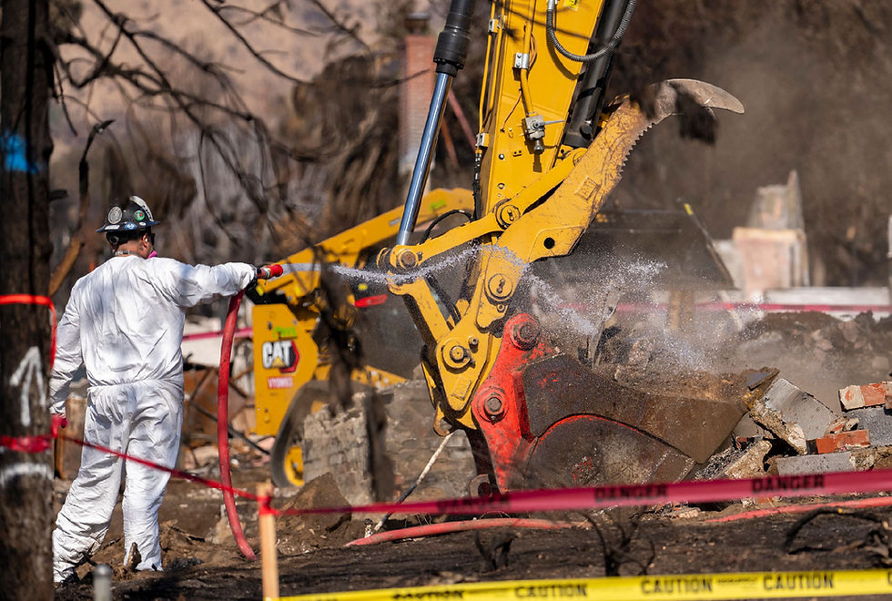 Operator supervising use of heavy digging equipment to pick up debris left by Eaton fire.