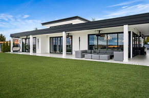 white with black trim modern home back yard covered patio with entertainment area