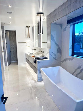 beautiful all quartz bathroom tiled walls, floors, and double sink with full glass shower and white bathtub
