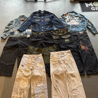 Custom jeans and jackets spread out on the floor