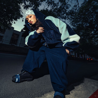 girl with baggy pants, blue sweat shirt an bandana, posing for camera