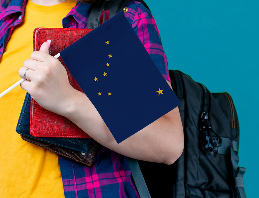 A white girl with book bag and Alaska flag on a turquoise background
