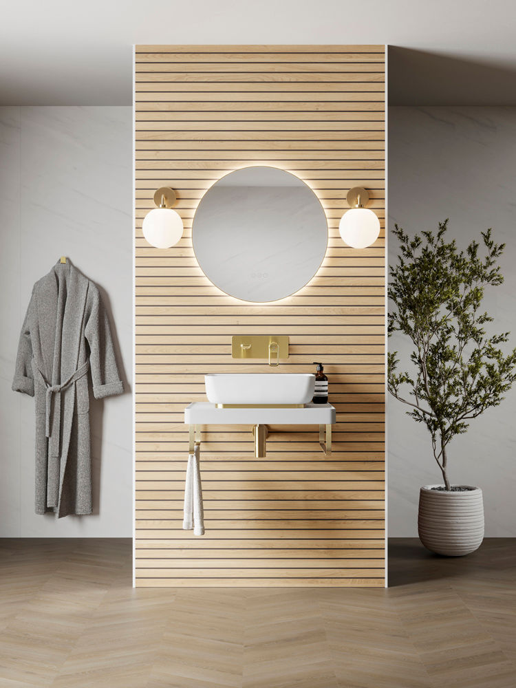 Modern bathroom with wooden slat wall, round mirror, and dual lights. White sink with gold fixtures. Gray robe hangs, potted plant nearby.