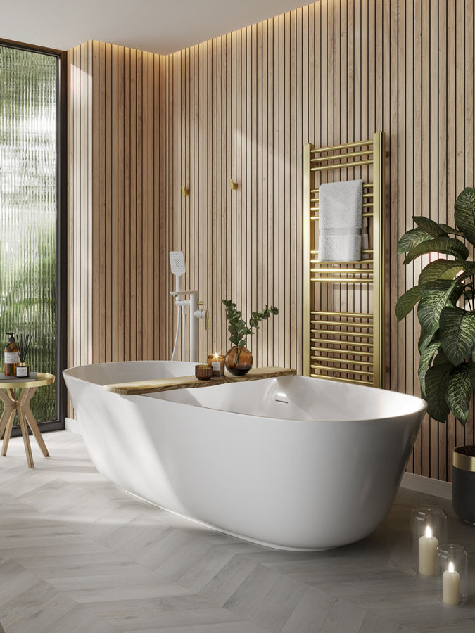 Luxurious bathroom with freestanding white tub, wood panel walls, gold towel rack, plants, and candles, creating a serene spa-like ambiance.
