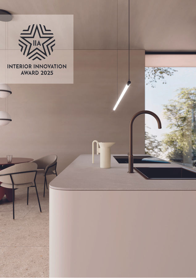 Modern kitchen with sleek faucet, cream countertop, white jug, and pendant lamp. Large window shows trees. Text: Interior Innovation Award 2025.