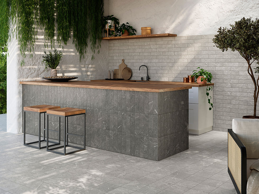 Modern kitchen with gray stone island, wooden countertop, and stools. Green plants hang above, with potted plants on white shelves.
