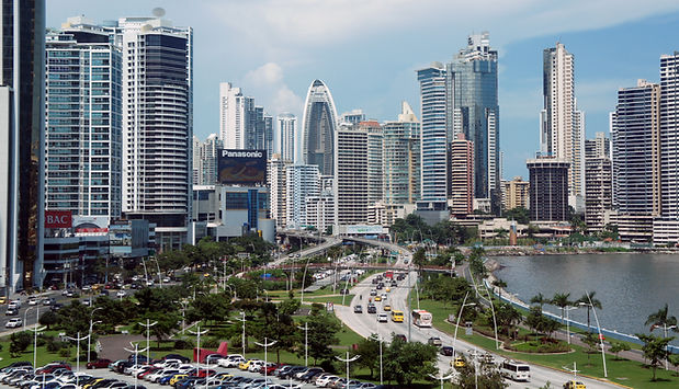 City skyline with tall buildings, waterfront, and busy road with cars