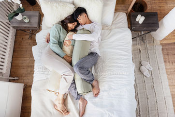 Lifestyle product image for a sleep brand showing a couple posing in bed in a Toronto studio.