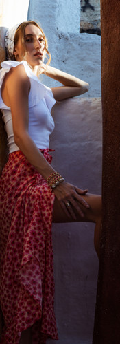 Beautiful model in Mediterranean dress and headband poses for natural light photoshoot in greece at golden hour