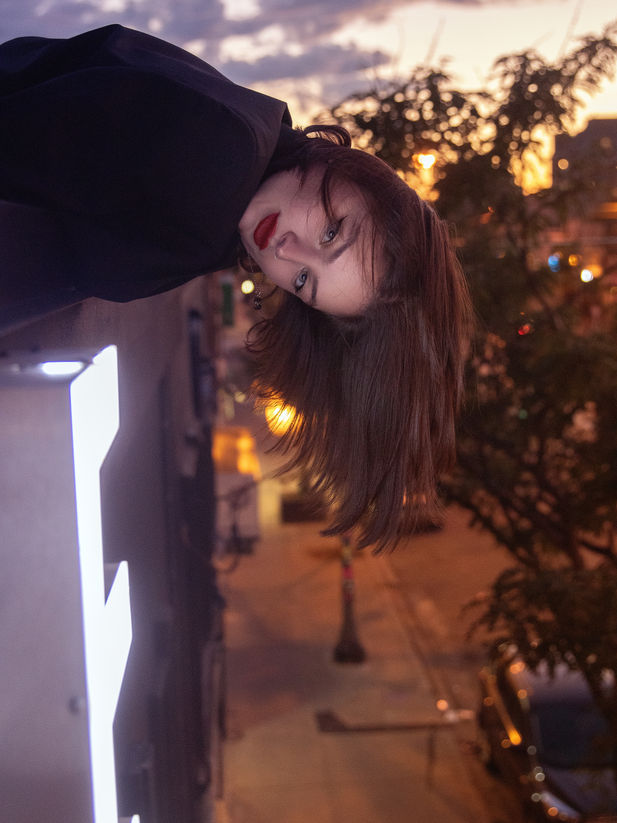 A beautiful model hangs off the roof of a Toronto hotel photographed by Isaiah Haber. 