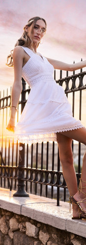 Beautiful model in Mediterranean dress and headband poses for natural light photoshoot in greece at golden hour